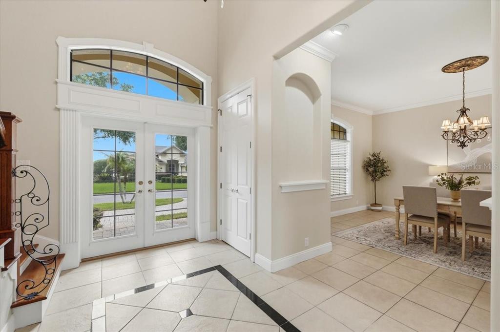 An entryway with tile floors, a double front door, and a view into a dining room — 5112 HIGHLANDS LAKEVIEW LOOP, LAKELAND, FL