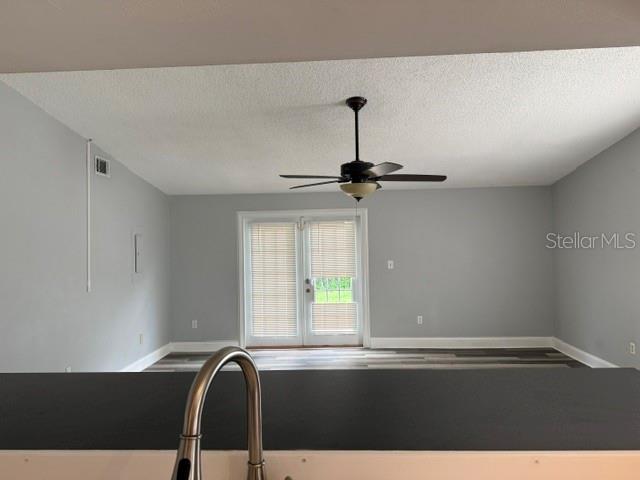 A view from a kitchen counter looking toward a living area with glass doors — 2857 CINNAMON BEAR TRAIL, PALM HARBOR, FL