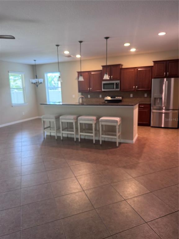 A screened-in patio features a ceiling fan, concrete flooring, and views of a backyard — 8302 KARPEAL DRIVE, SARASOTA, FL