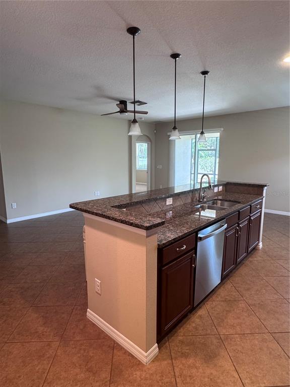 A screened-in patio features a ceiling fan, concrete flooring, and views of a fenced yard — 8302 KARPEAL DRIVE, SARASOTA, FL