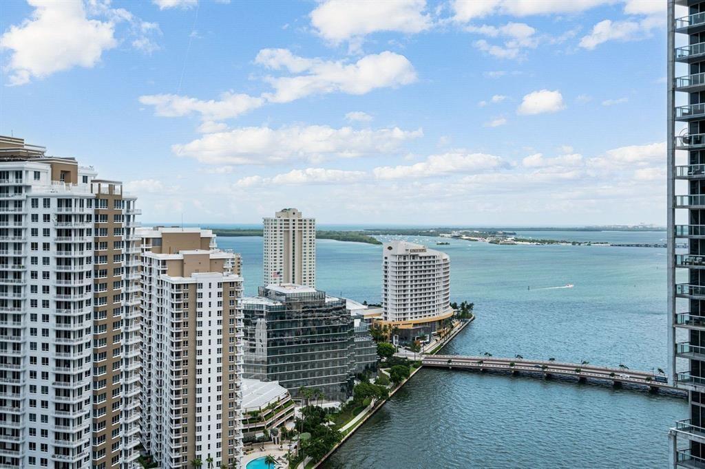 A balcony view overlooking a canal surrounded by modern high-rise buildings in Miami — 465 Brickell Avenue # 2706, Miami FL 33131, MIAMI, FL