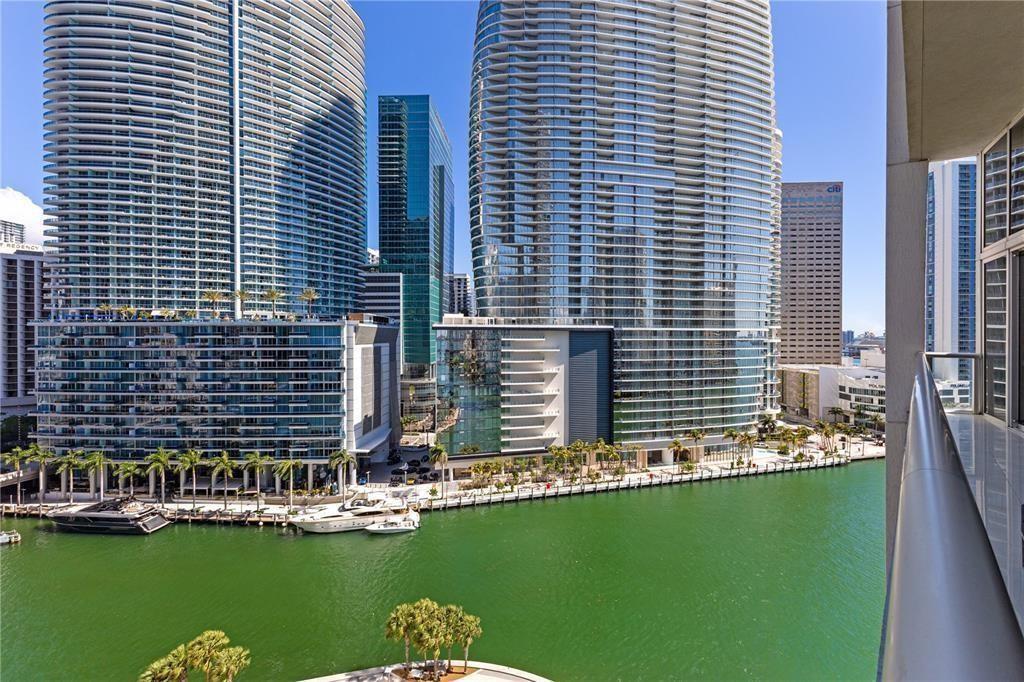 An elevated night view of a city skyline featuring a large modern skyscraper and river — 465 Brickell Avenue # 2706, Miami FL 33131, MIAMI, FL
