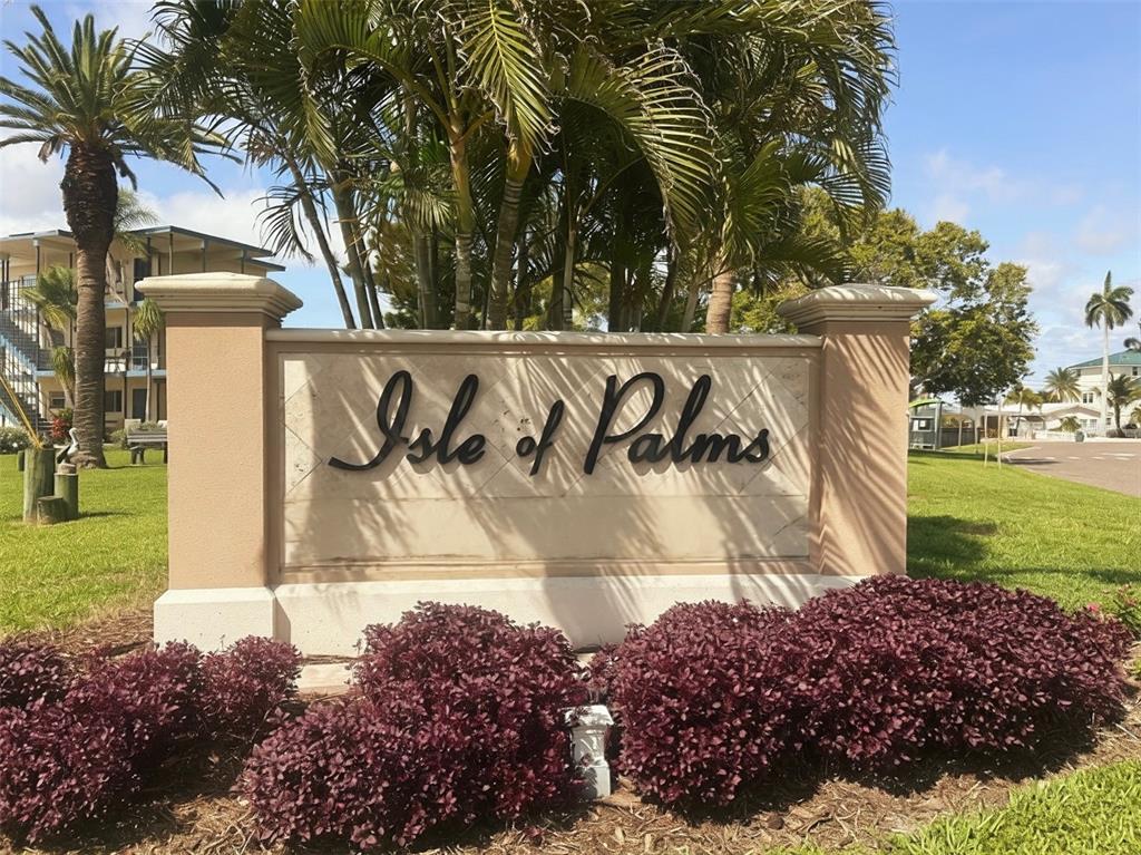 A single-story house with a white exterior, a two-car garage, and a large palm tree — 155 112TH AVENUE UNIT A, TREASURE ISLAND, FL
