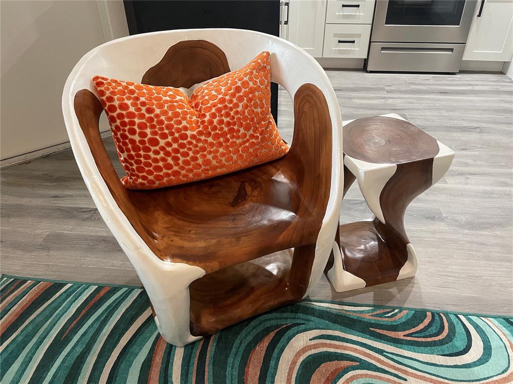 A wooden chair and matching side table with white accents sit on a patterned rug — 1912 MORRILL UNIT 1916, SARASOTA, FL