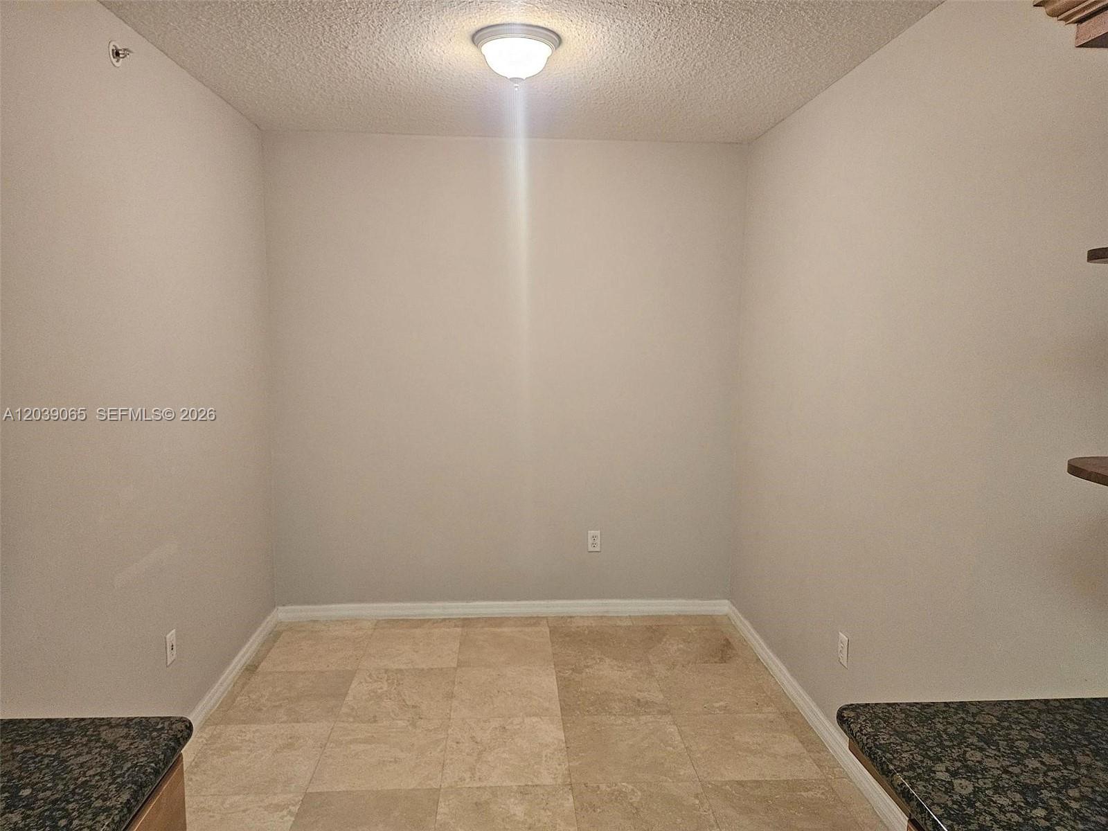 An empty room features light-colored walls, a textured ceiling, and tan tile flooring — 3530 SW 22nd St # 505, Miami FL 33145, MIAMI, FL