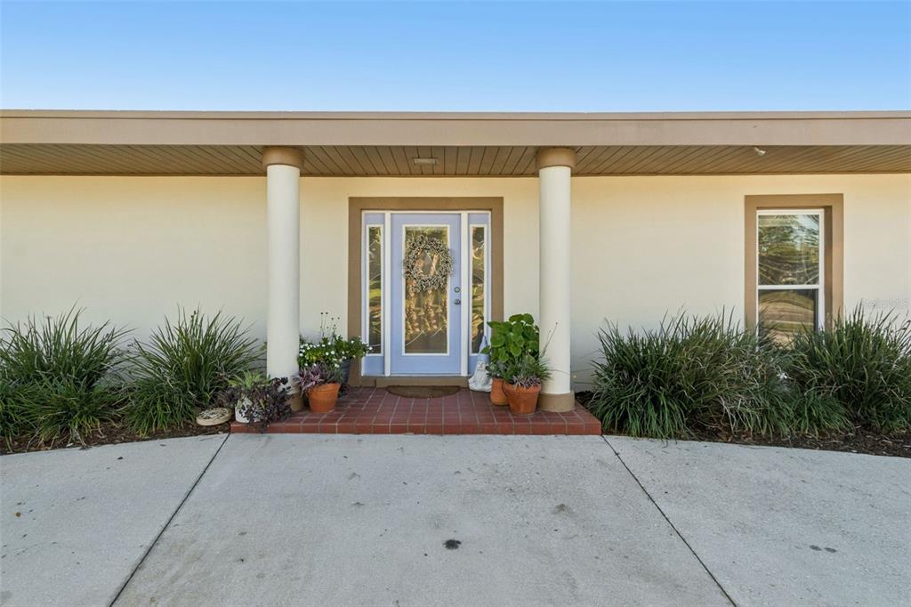 A light blue front door sits between two columns under a wide, covered porch — 618 WHITFIELD AVENUE, SARASOTA, FL