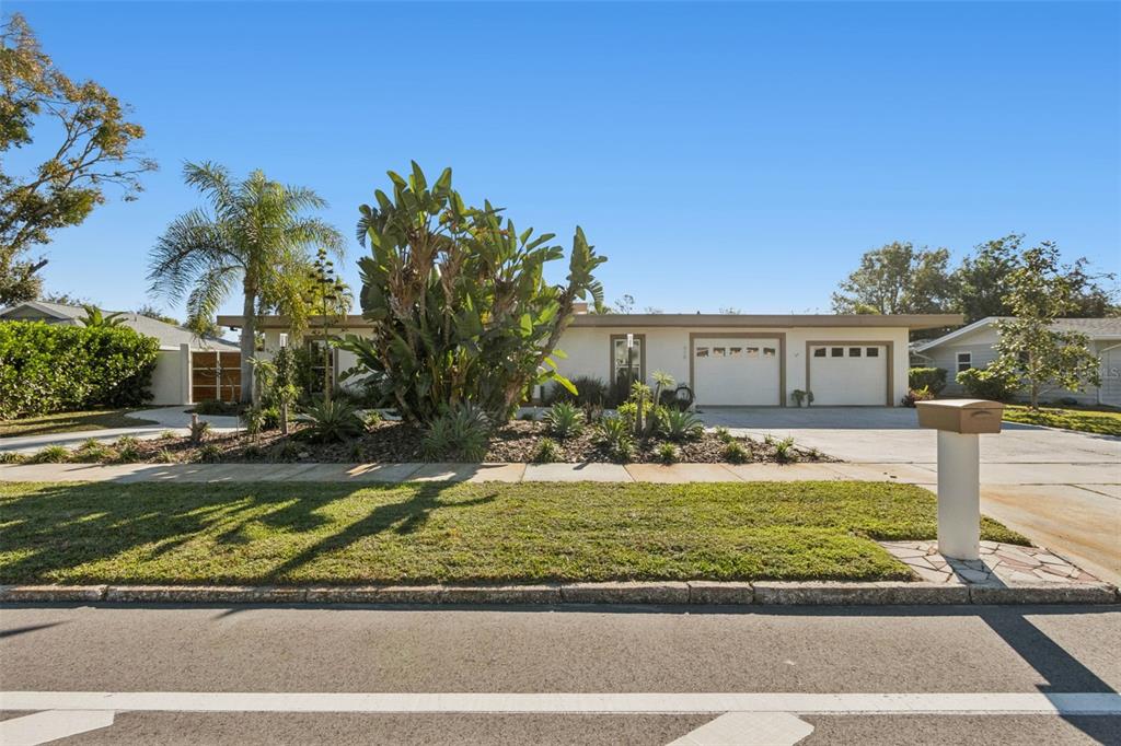 A single-story house with a two-car garage, palm trees, and landscaping under a clear sky — 618 WHITFIELD AVENUE, SARASOTA, FL