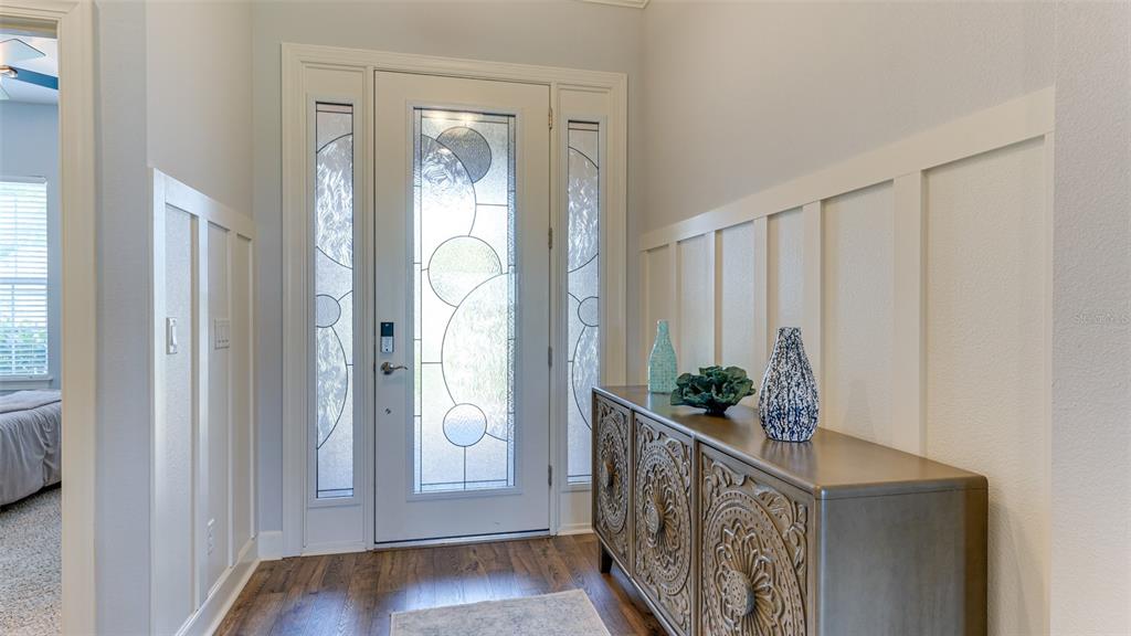 An entryway features a white front door with decorative glass, wainscoting, and a wooden console — 4511 TERRAZZA COURT, LAKEWOOD RANCH, FL