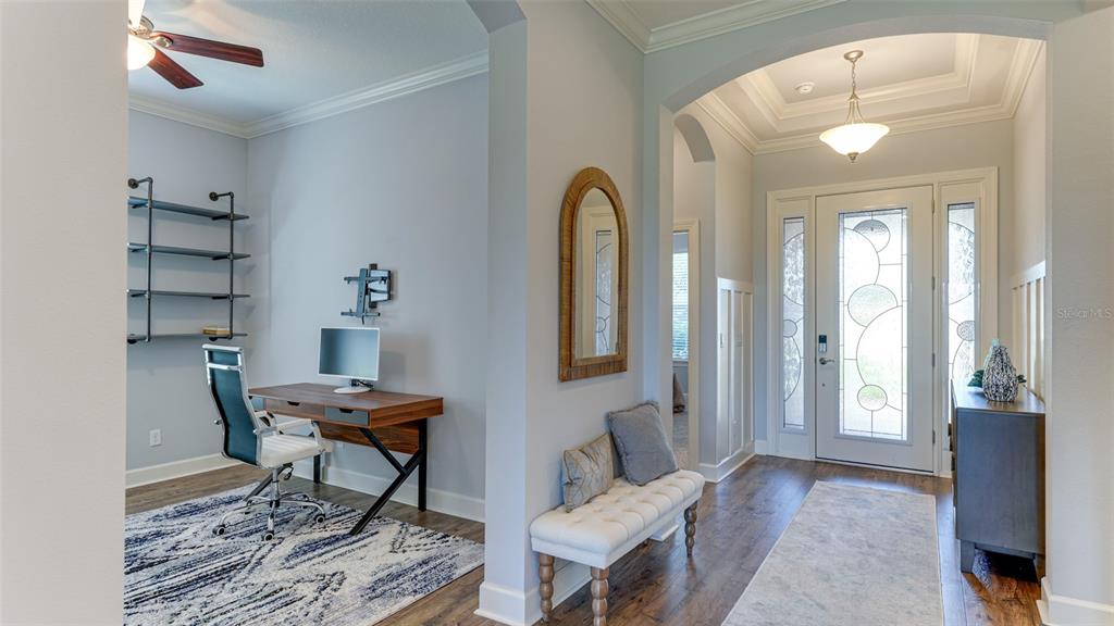 A home office with a desk and shelving sits beside an entryway with a bench — 4511 TERRAZZA COURT, LAKEWOOD RANCH, FL