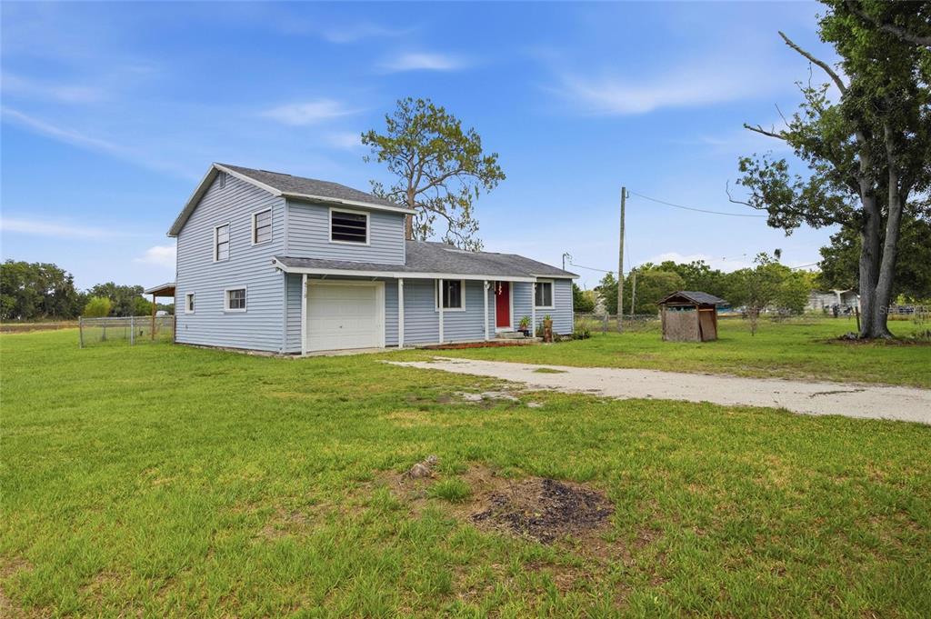 A two-story light blue house with a garage and a large grassy yard — 4710 CORONET ROAD, PLANT CITY, FL