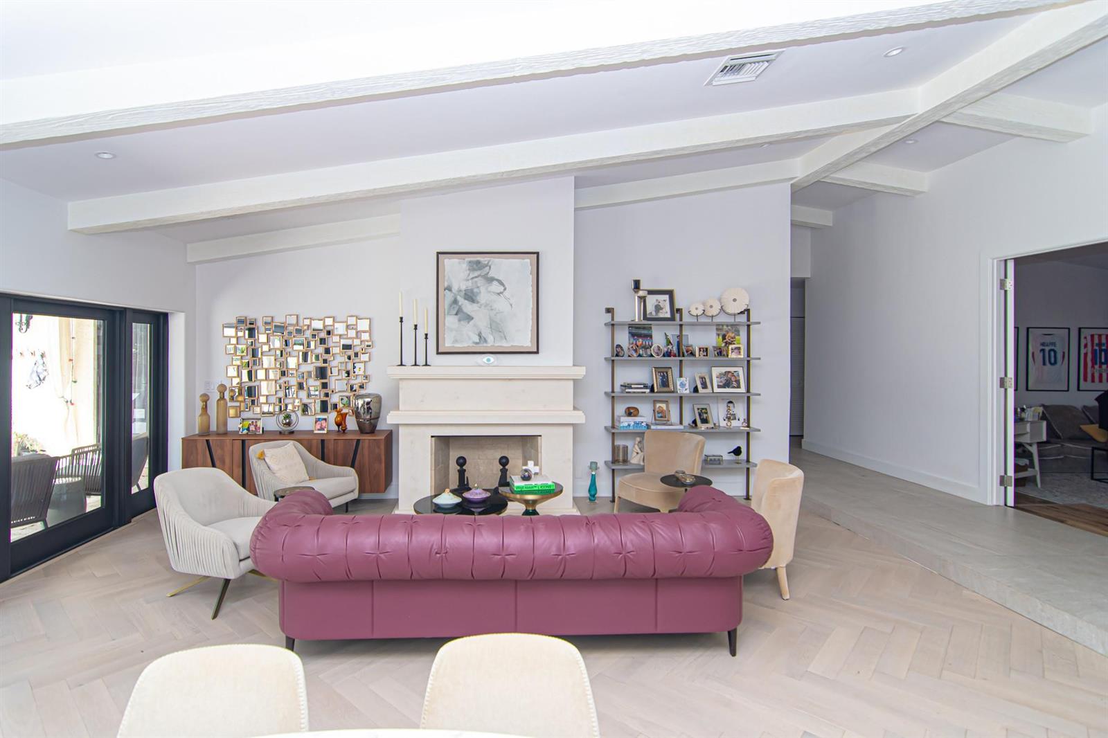A living room features a purple tufted sofa, a fireplace, and light wood flooring — 8208 Twin Lake Drive, Boca Raton FL 33496, BOCA RATON, FL