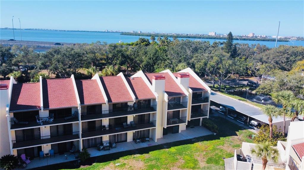 An aerial view of a multi-story apartment building with balconies overlooking a body of water — 7550 SUNSHINE SKYWAY LANE S UNIT P11, ST PETERSBURG, FL