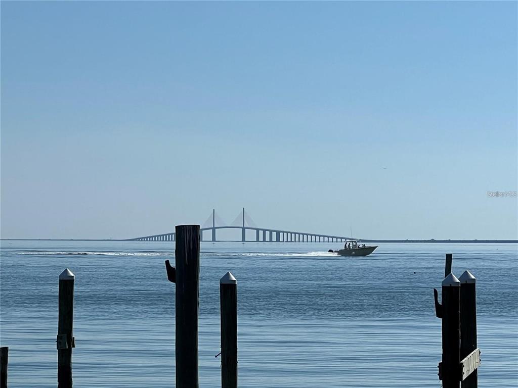 A view of the Sunshine Skyway Bridge across the water with wooden pilings in foreground — 7550 SUNSHINE SKYWAY LANE S UNIT P11, ST PETERSBURG, FL