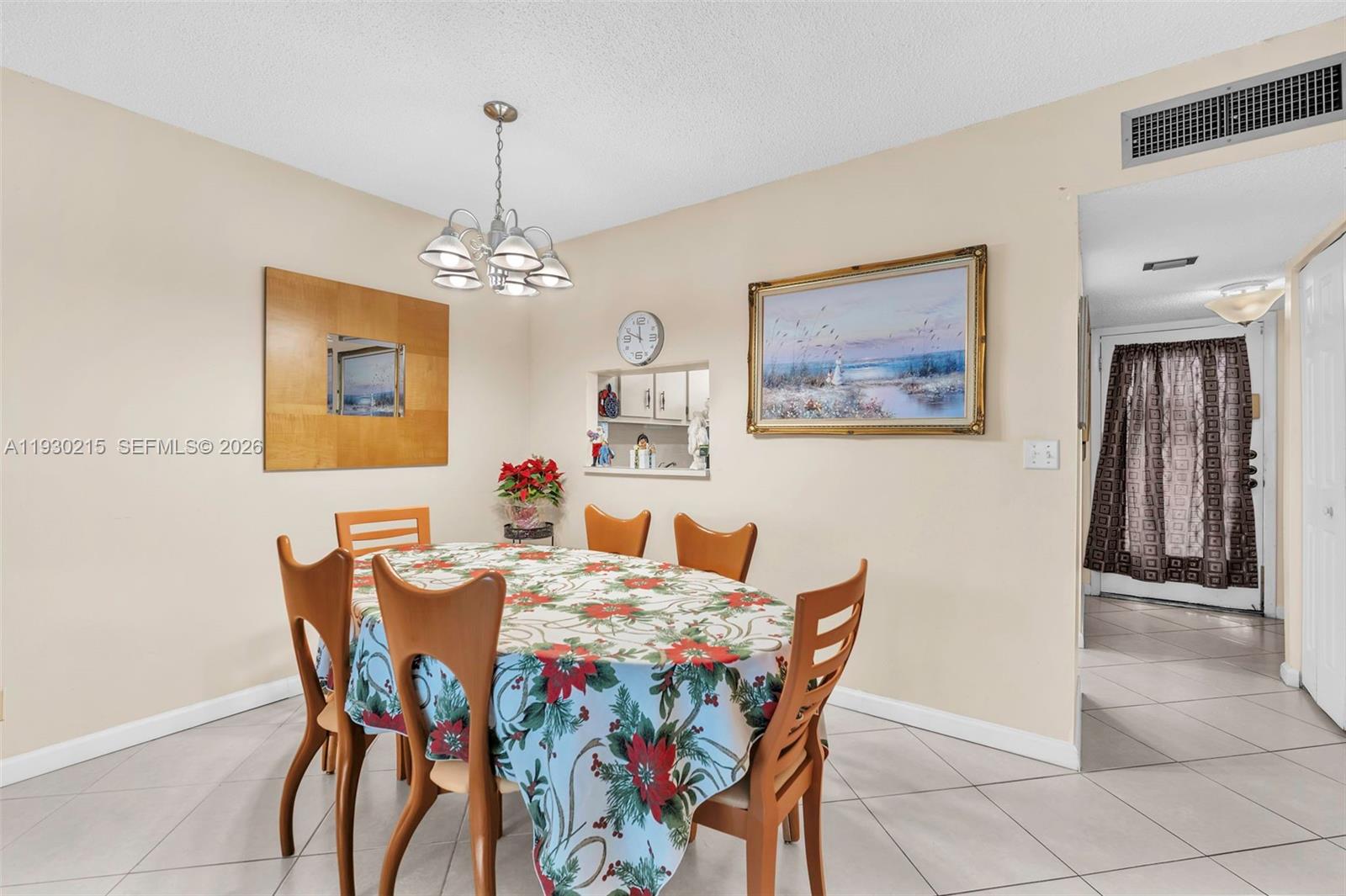 A dining room with a table, chairs, a chandelier, and a pass-through to the kitchen — 3100 Holiday Springs Blvd # 304, Margate FL 33063, MARGATE, FL