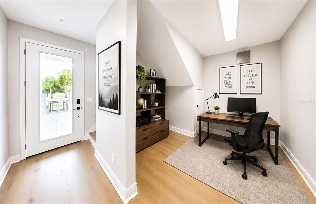 A home office with a desk, bookshelf, and an adjacent exterior door with a glass panel — 7227 NEMOURS PARKWAY, ORLANDO, FL