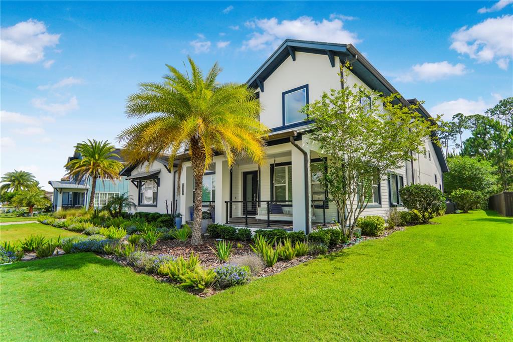 A two-story house with a white exterior, dark trim, a front porch, and palm trees — 12803 UPPER HARDEN AVENUE, ORLANDO, FL