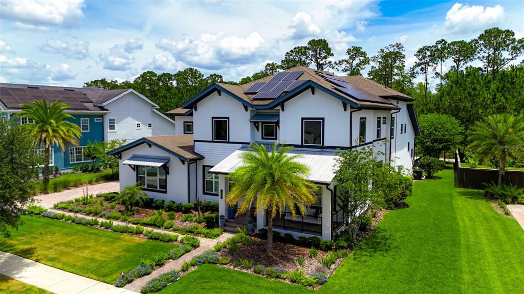 An exterior view of a two-story white house with solar panels and a palm tree — 12803 UPPER HARDEN AVENUE, ORLANDO, FL