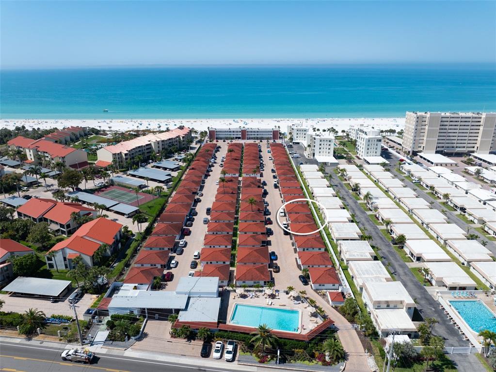 An aerial view shows a beachside residential complex with rows of villas and a pool — 6154 MIDNIGHT PASS ROAD UNIT A-05, SARASOTA, FL