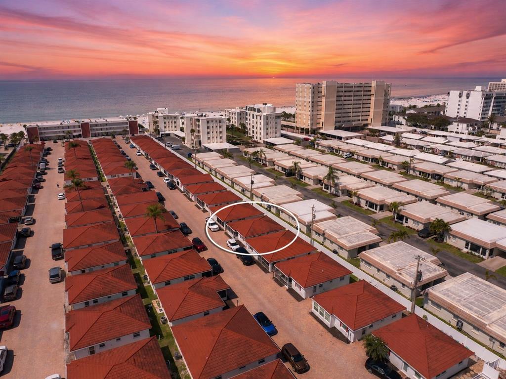 An aerial view shows a row of residential villas with red roofs near the beach — 6154 MIDNIGHT PASS ROAD UNIT A-05, SARASOTA, FL