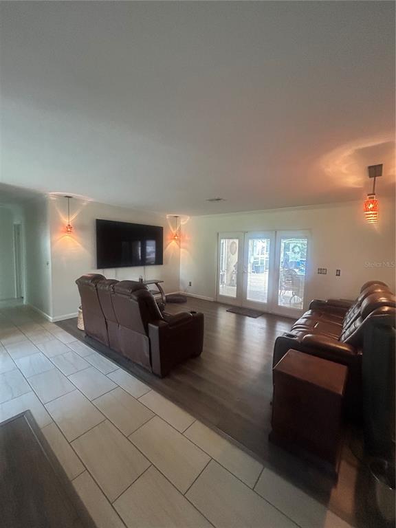 A living room features brown leather recliners, a wall-mounted television, and wood-look flooring — 2935 PLANTATION ROAD, WINTER HAVEN, FL