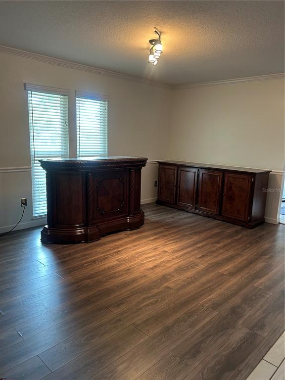 A room with wood-look flooring, a dark wood bar, a matching sideboard, and two windows — 2935 PLANTATION ROAD, WINTER HAVEN, FL