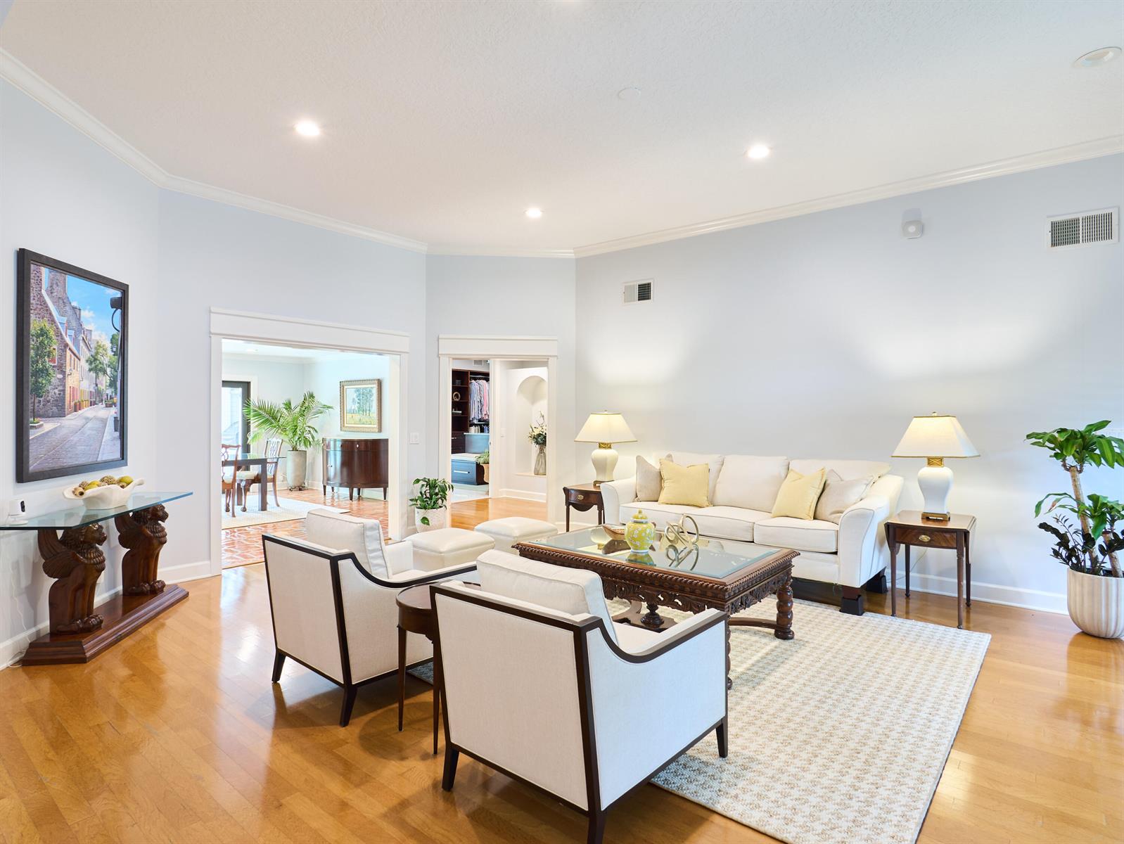 A living room features white sofas, two armchairs, a glass-topped coffee table, and hardwood floors — 3700 Embassy Drive, West Palm Beach FL 33401, WEST PALM BEACH, FL