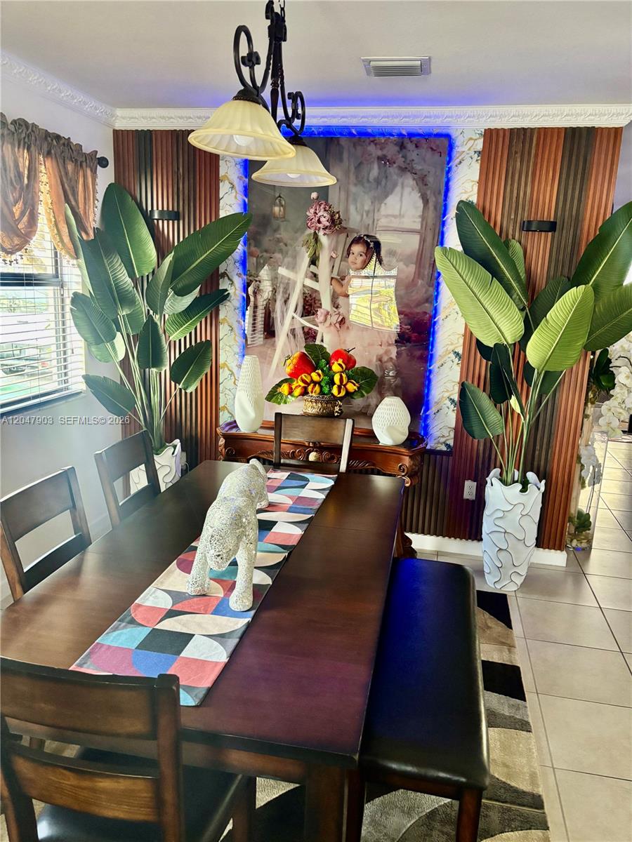 A two-story house features a stone-accented entryway, a dark garage door, and a brick driveway — 11406 SW 252nd Ter, Homestead FL 33032, HOMESTEAD, FL