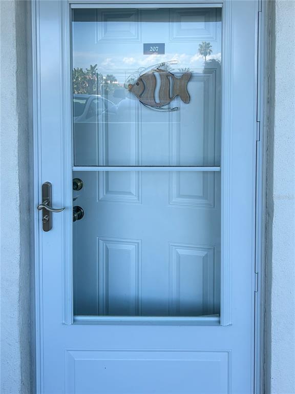 A light blue storm door with a glass panel and a decorative fish ornament — 1230 GULF BOULEVARD UNIT 207, CLEARWATER BEACH, FL