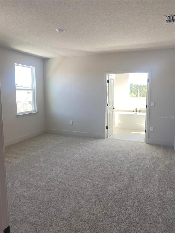 A kitchen coffee station features white cabinets, light countertops, under-cabinet lighting, and wood-look flooring — 9493 EMERALD BERRY DRIVE, WINTER GARDEN, FL