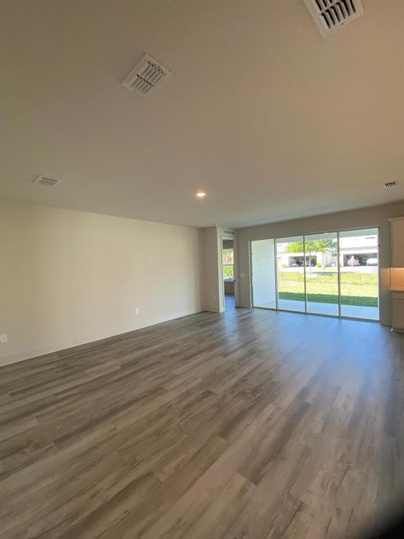 An open-concept kitchen and dining area features light wood flooring and modern pendant lighting — 9493 EMERALD BERRY DRIVE, WINTER GARDEN, FL