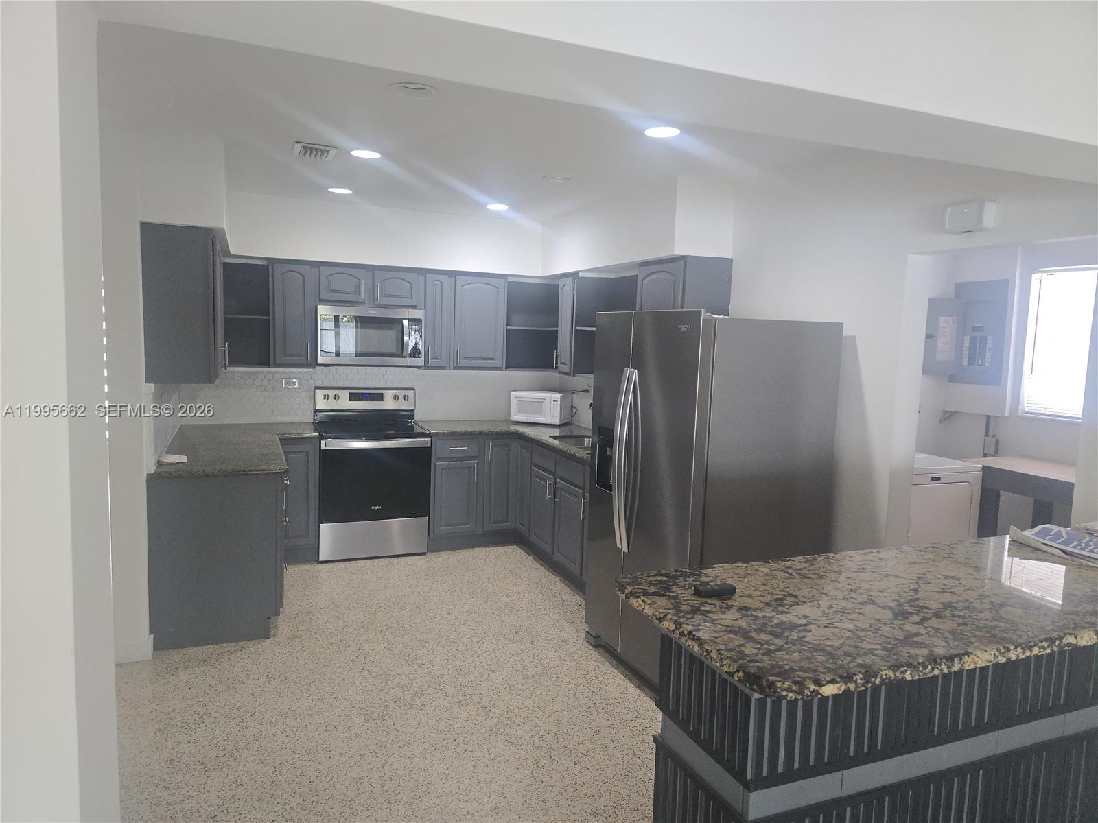 A kitchen features gray cabinetry, granite countertops, stainless steel appliances, and a speckled floor — 9725 SW 15th St, Miami FL 33174, MIAMI, FL