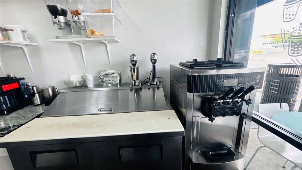 A commercial kitchen area features a soft-serve ice cream machine and a stainless steel counter — 2454 MCMULLEN BOOTH ROAD UNIT 303, CLEARWATER, FL