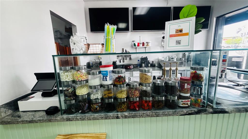A commercial service counter features glass display jars filled with various toppings and snacks — 2454 MCMULLEN BOOTH ROAD UNIT 303, CLEARWATER, FL