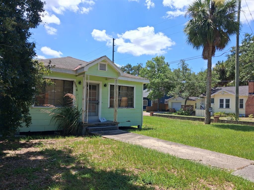 A light green, single-story house with a front porch and a concrete walkway — 217 BANANA STREET, TARPON SPRINGS, FL