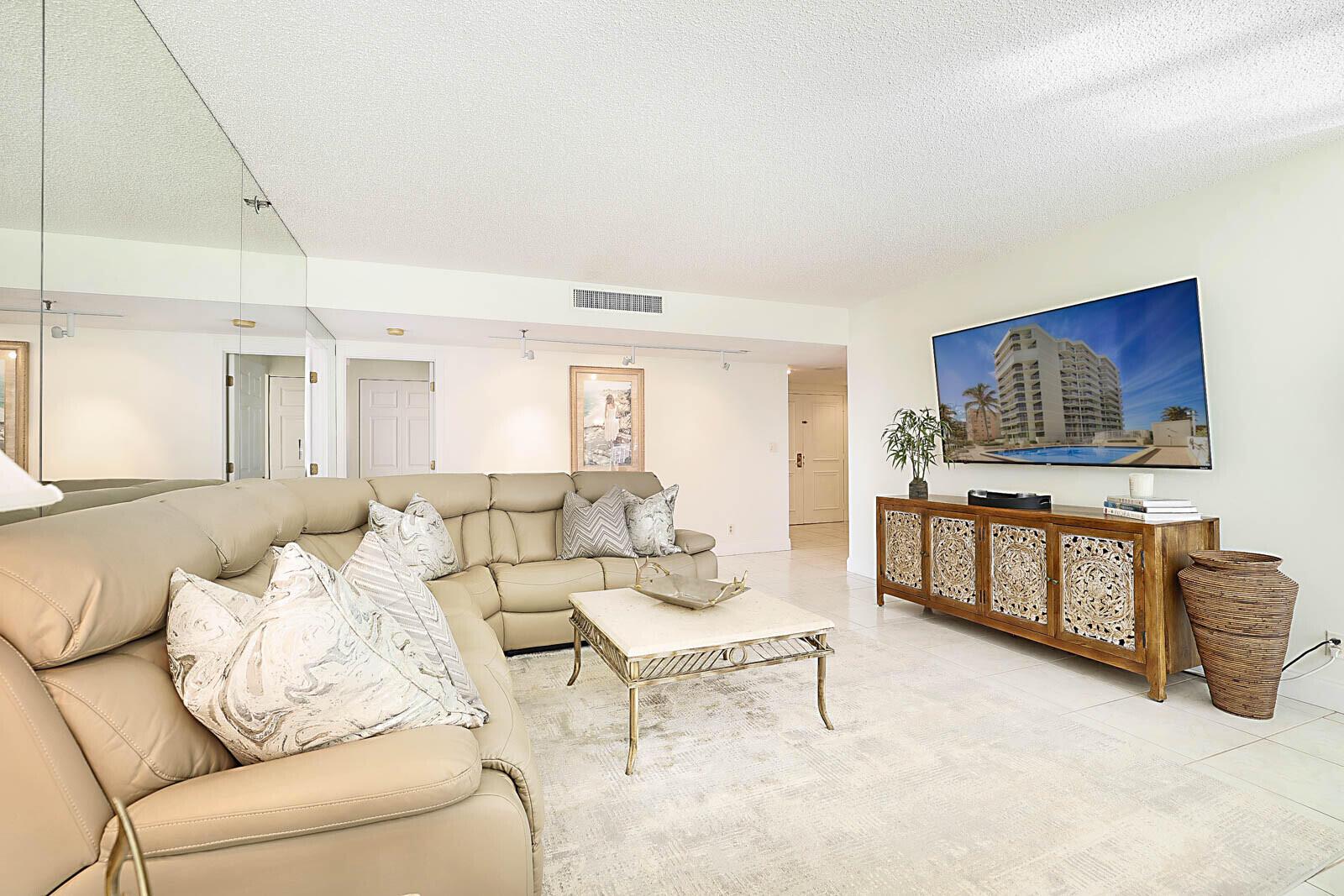 A living room features a beige leather sectional, a stone coffee table, and a carved cabinet — 2917 S Ocean Boulevard # 405, Highland Beach FL 33487, HIGHLAND BEACH, FL
