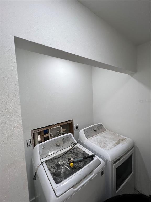 A laundry area features a washer and dryer beneath a recessed wall alcove — 6138 OAK CLUSTER CIRCLE, TAMPA, FL