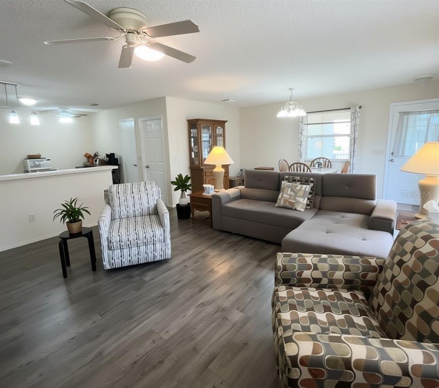 A yellow single-story house with a white picket fence, a garage, and a screened porch — 16938 SE 94TH SUNNYBROOK CIRCLE, THE VILLAGES, FL