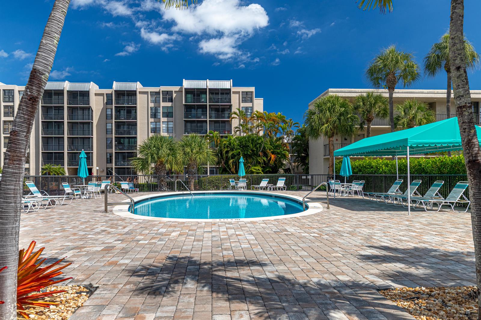 A screened-in balcony features outdoor seating overlooking a canal and multi-story residential buildings — 6 Royal Palm Way # 211, Boca Raton FL 33432, BOCA RATON, FL