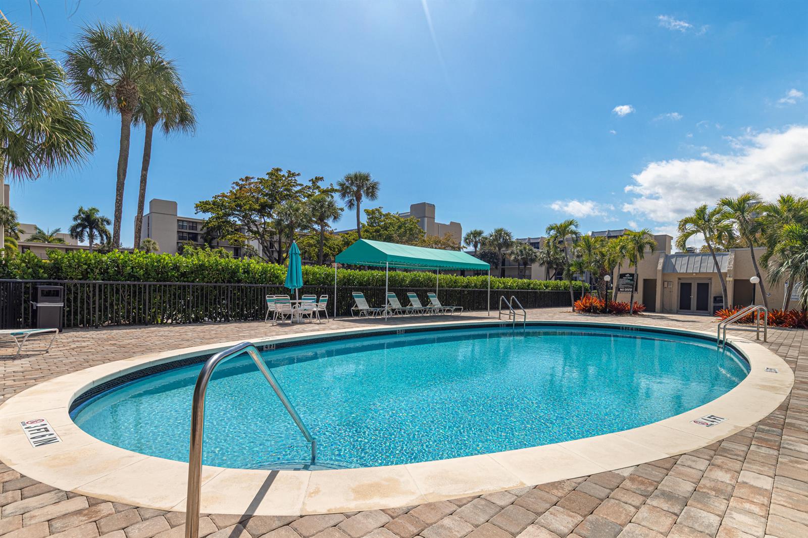 A view of a canal and apartment buildings from a screened-in balcony with railings — 6 Royal Palm Way # 211, Boca Raton FL 33432, BOCA RATON, FL