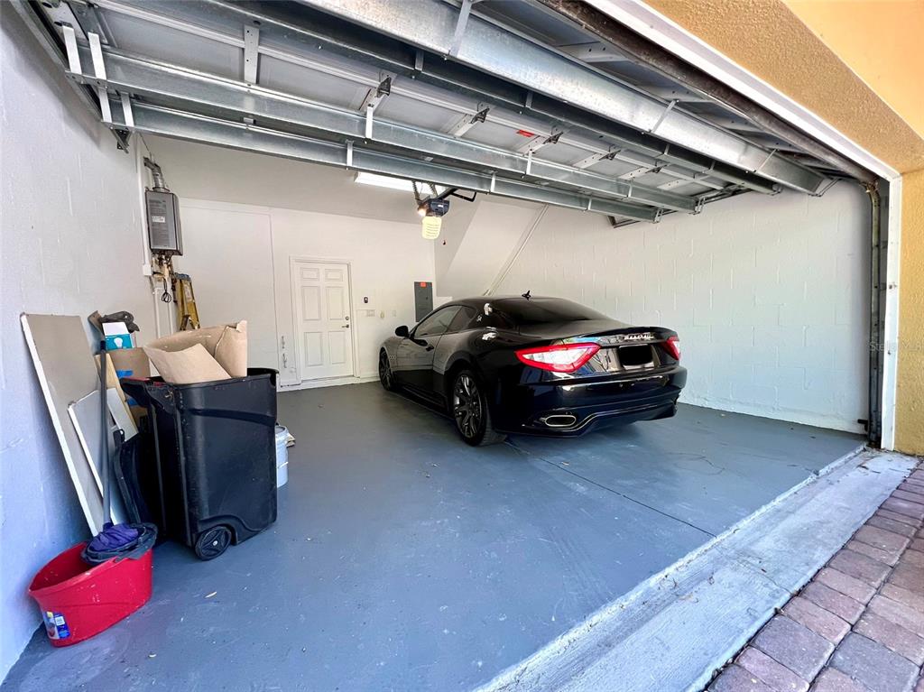 A black sports car is parked inside a garage with a gray floor — 809 HARBOR OAK LANE, CLEARWATER, FL