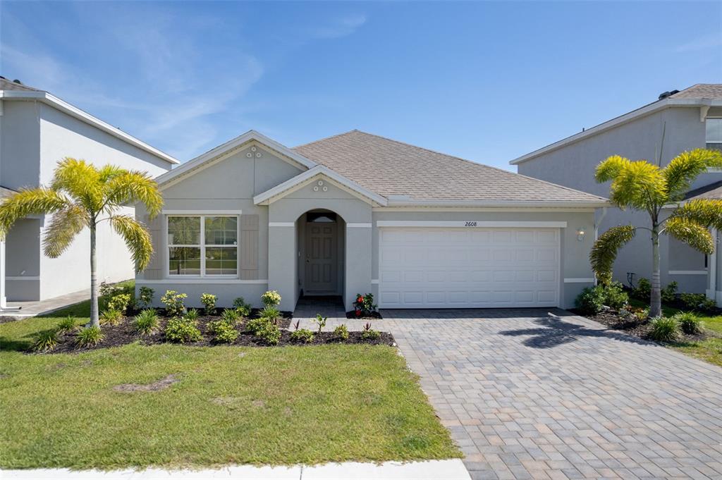 A single-story house with a gray exterior, a paved driveway, and two palm trees — 2608 TABLE CORAL TRAIL, NORTH FORT MYERS, FL