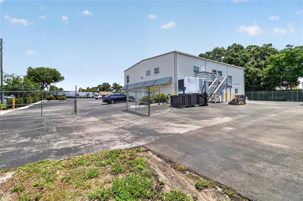 A two-story commercial building features a metal exterior, an outdoor staircase, and a paved parking lot — 513 ARIANA AVENUE, AUBURNDALE, FL