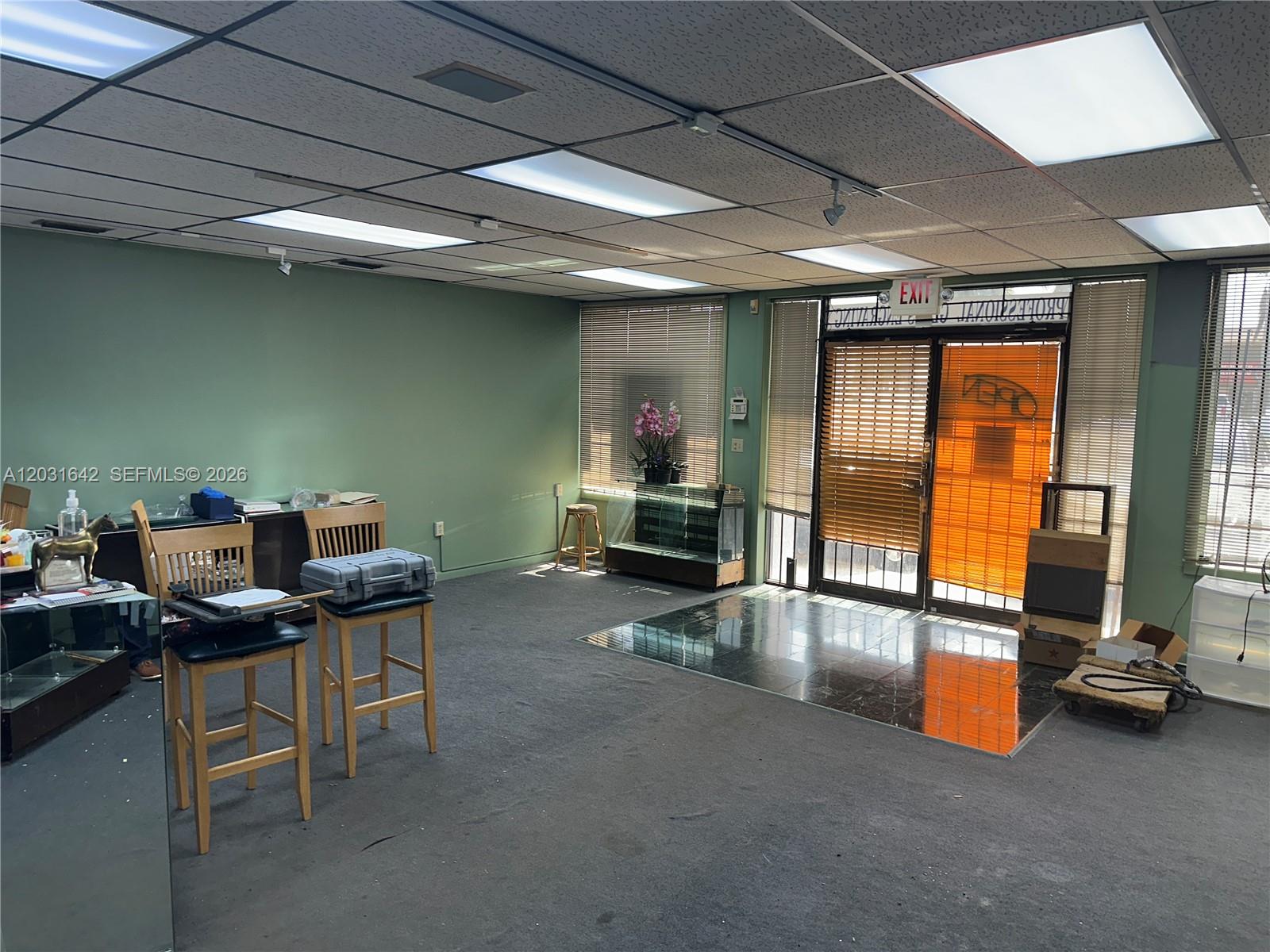 An office space features green walls, a drop ceiling with recessed lights, and carpeted flooring — 3960 W 16th Ave # 205, Hialeah FL 33012, HIALEAH, FL
