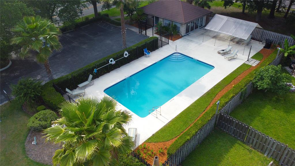An aerial view shows a rectangular swimming pool surrounded by a patio, landscaping, and fencing — 2509 NW 37TH PLACE, GAINESVILLE, FL