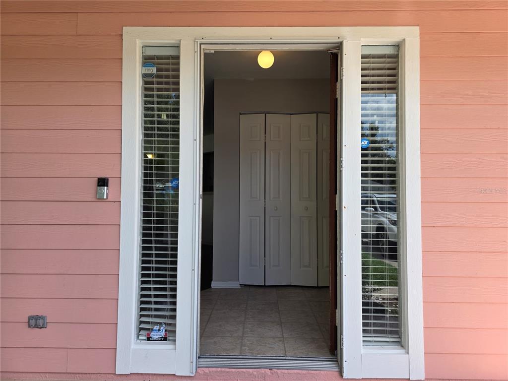 The front entryway features a door flanked by two sidelight windows on a pink exterior — 2509 NW 37TH PLACE, GAINESVILLE, FL