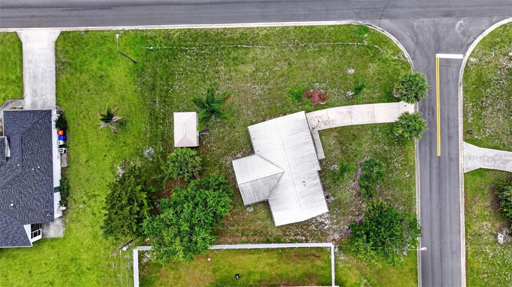 An aerial view shows a house with a metal roof, a shed, and a driveway — 2296 18TH AVE SW, VERO BEACH, FL
