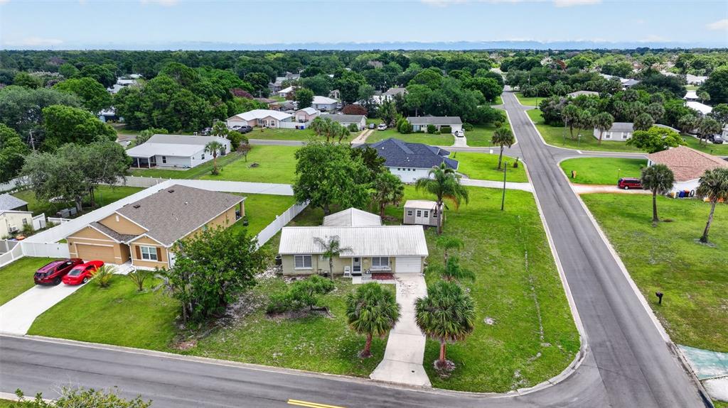 An aerial view shows two residential houses with driveways and lawns in a suburban neighborhood — 2296 18TH AVE SW, VERO BEACH, FL