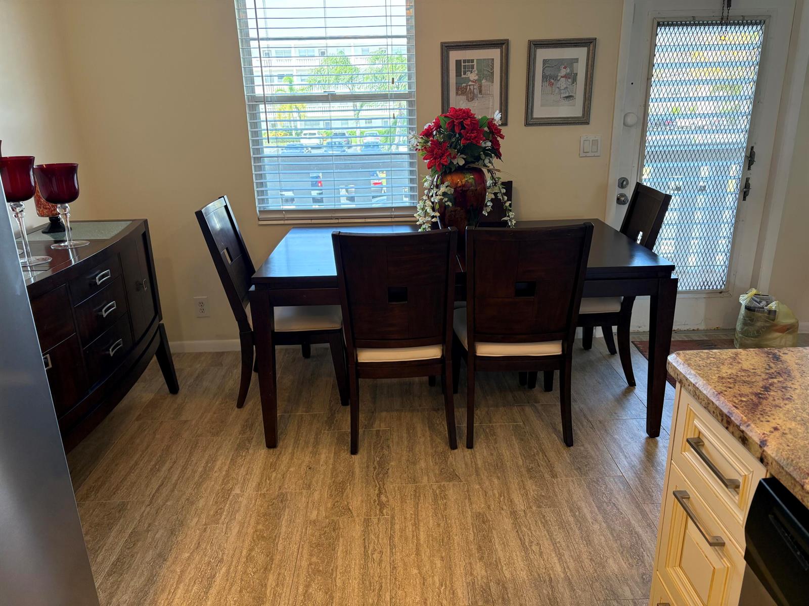A dining area features a dark wood table and chairs, tile flooring, and a window — 2024 Rexford # B, Boca Raton FL 33434, BOCA RATON, FL