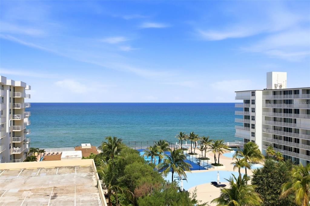 An elevated view of a beachside resort with swimming pools, palm trees, and the ocean — 3540 S OCEAN BOULEVARD UNIT 808W, PALM BEACH, FL