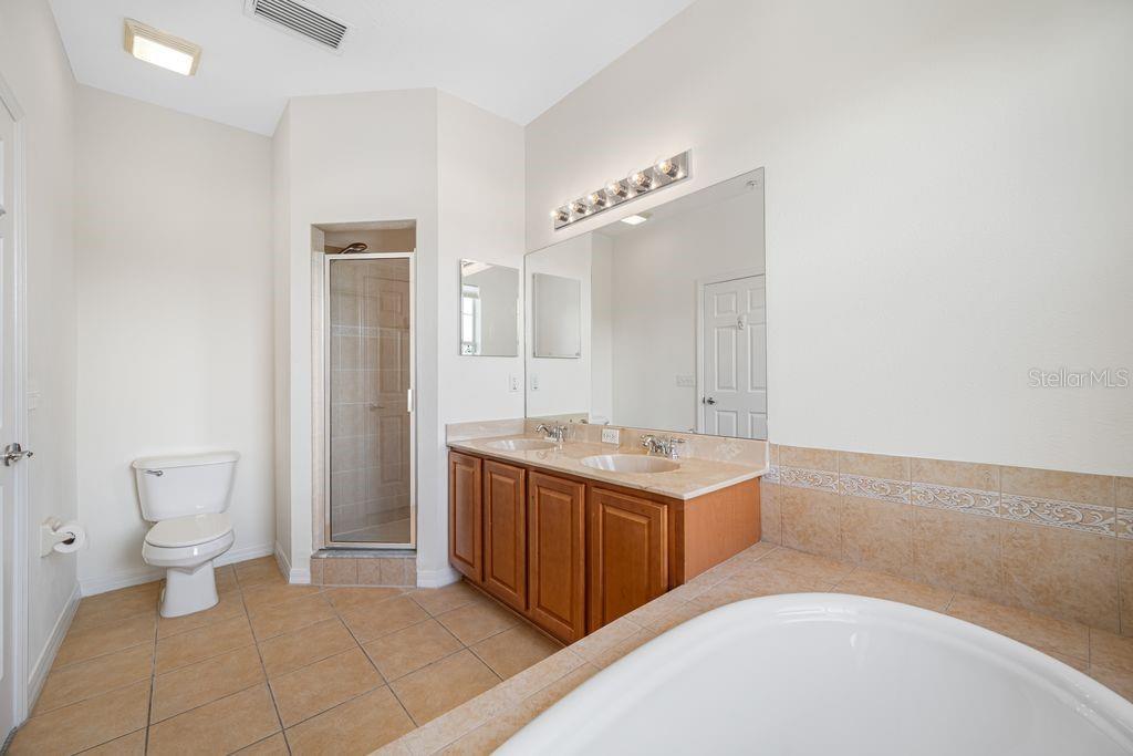 A bathroom features a double vanity, a walk-in shower, a soaking tub, and tile flooring — 7125 102ND LANE, SEMINOLE, FL